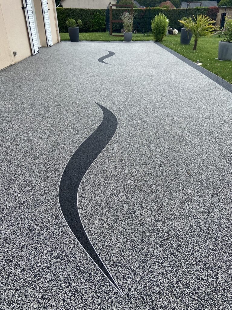 Terrasse en moquette de pierre avec un motif noir ondulé à Rouen